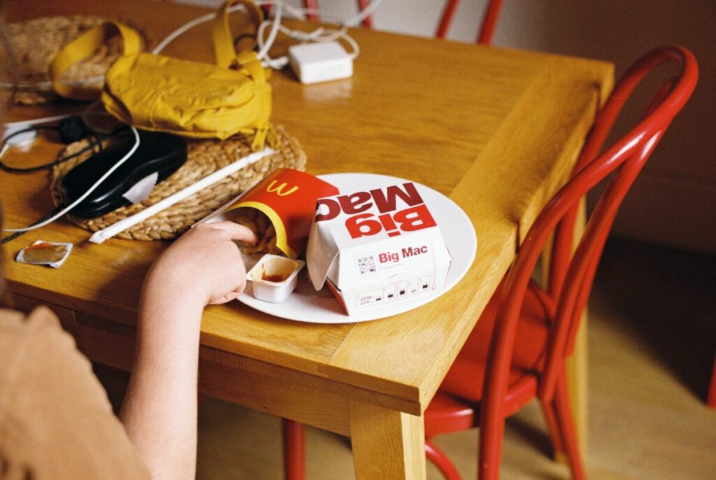ビッグマックとポテトをテーブルに置いて食べているところ